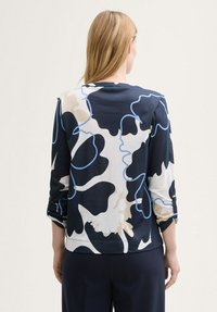 Pikad varrukad blouse tumesinise taustaga, millel on suured abstraktsed lillemustrid valge ja helesinise värviga. Pehme, kerge kangas.