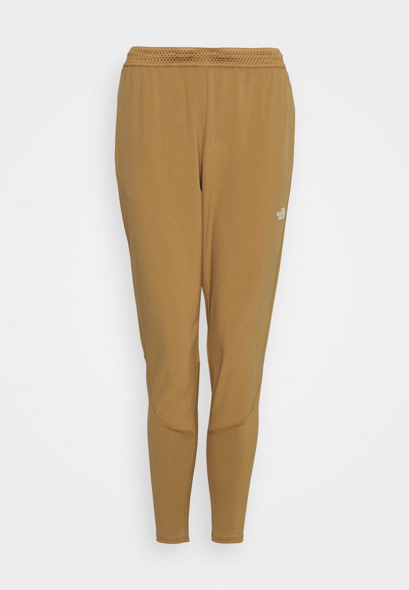 Bruna träningsbyxor med en figurnära design, tillverkade av ett glatt material. Har en mesh-midja och en subtil varumärkeslogga på sidan.