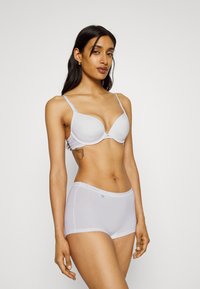 Light grey bra with lace trim and a smooth finish, paired with matching hipster shorts featuring a soft waistband and seamless design.