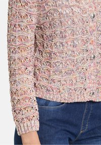 Strickjacke mit einem bunten, strukturierten Muster in pastellfarbenen Tönen. Verfügt über silberne Knöpfe und gerippte Bündchen und Saum.