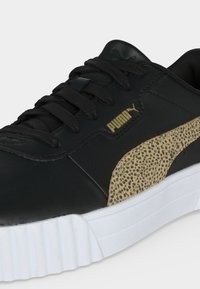 Μαύρο αθλητικό παπούτσι Puma με λευκή σόλα, μαύρα κορδόνια, χρυσό λογότυπο Puma και ταμπά λεπτομέρεια με σχέδιο λεοπάρ στην πλαϊνή επιφάνεια.