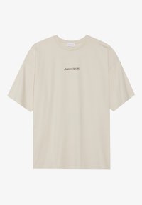Camiseta de manga corta beige, hecha de algodón suave, con un cuello redondo y texto negro que dice "POSITIVO SINCERO" en la parte delantera.