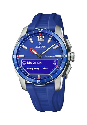 Montre en titane avec un bracelet en caoutchouc bleu ; cadran bleu avec des index blancs, aiguilles rouge et verte, et un affichage numérique pour des fonctionnalités supplémentaires.