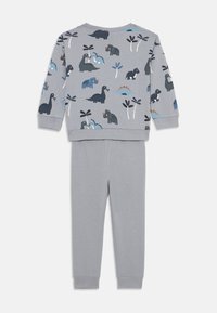 Completo grigio a due pezzi con una maglia a maniche lunghe decorata con stampe colorate di dinosauri e piante, abbinata a pantaloni grigi con cintura elastica.