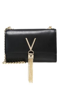 Svart läder crossover-väska med en guldkedjeslinga, framträdande guld "V" logotypdetalj och en tofsdetalj. Enkel och strukturerad design.