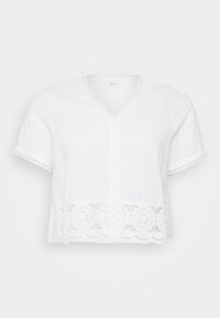 White short-sleeve blouse in light fabric, featuring a V-neck, button closure, and a decorative lace hem with circular patterns.
