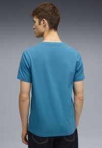 Trumpas rankovės marškinėliai iš ryškiai mėlyno medvilninio audinio, apvalios kaklo iškirpės dizainas, lygus paviršius, su žyme šone ir tvirtu įsitempimu liemenyje.