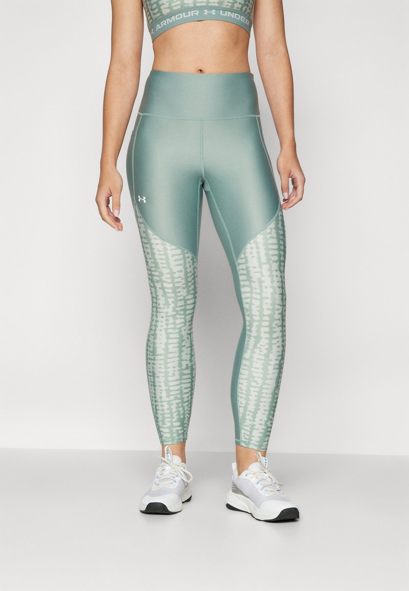 Leggings atléticos verde claro con un patrón texturizado blanco en las piernas y una cintura alta, combinados con un top corto a juego.