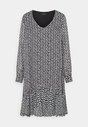 Sort-hvid langærmet V-hals kjole med lille abstrakt mønster og samlet flæsekant.