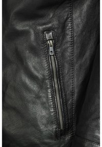 Chaqueta de cuero negro con una vista en primer plano de un bolsillo con cremallera, que presenta una cremallera de metal plateado y una superficie de cuero texturizada.
