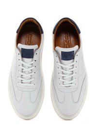 Baskets en cuir blanc avec une finition lisse, bout rond, accent en daim bleu marine sur le talon et doublure intérieure contrastante en tan.