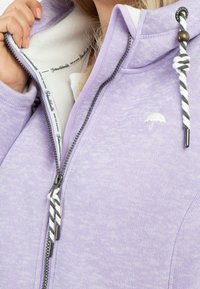 Jasnofioletowa bluza z kapturem na zamek, z miękkim, podszytym polarem kołnierzem. Posiada ozdobny suwak oraz małe logo parasola na piersi.