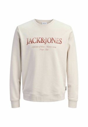 Sudadera color crema con cuello redondo, puños acanalados y un estampado gráfico frontal con "JACK&JONES" en una fuente audaz y desgastada.