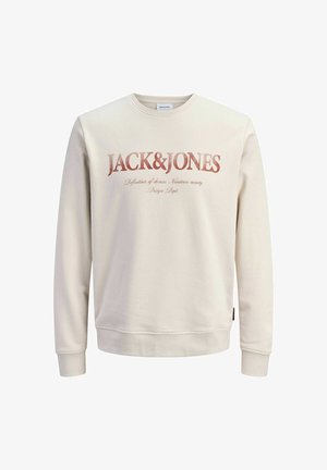 Kermanvärinen collegepaita, jossa on pyöreä pääntie, resoriset hihansuut ja edessä graafinen painatus, jossa lukee "JACK&JONES" rohkealla, kuluneen näköisellä fontilla.