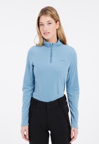 Pullover in fleece azzurro chiaro con mezza cerniera, caratterizzato da una superficie testurizzata e una vestibilità slim. Abbinato a pantaloni neri con tasche con cerniera.