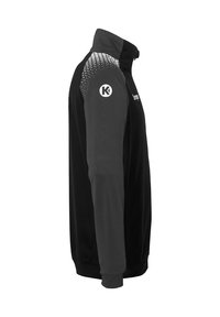 Sort zip-jakke med høj krave, der har grå mønstrede skuldre. Inkluderer logo påærmet og et glat, struktureret stof.