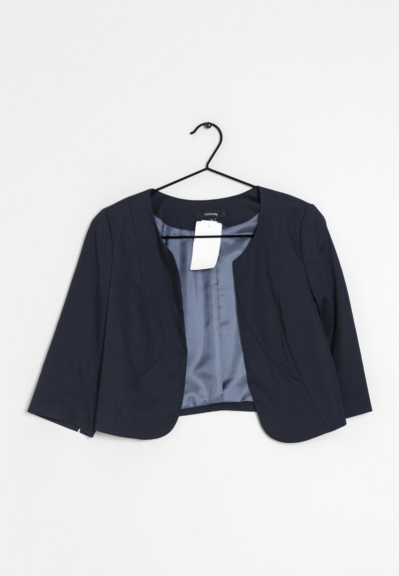 Blazer bleu marine court avec manches trois-quarts sur un cintre noir, sur fond blanc uni.