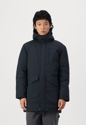 Black padded jacket with a high collar and adjustable hood. Features front pockets and a zip closure. Textured fabric and relaxed fit.