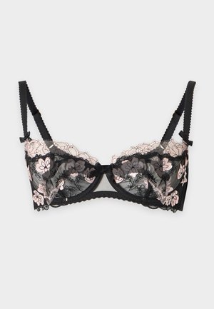 Soutien-gorge en dentelle noire avec broderie florale rose, bretelles réglables et petit nœud au centre, présenté sur un fond neutre.