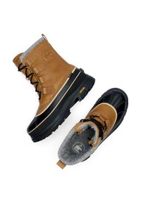 Vinterstövlar i brunt läder och svart gummi med grått fleecefoder, utrustade med snörning, Vibram-sula och logotypdetaljer.