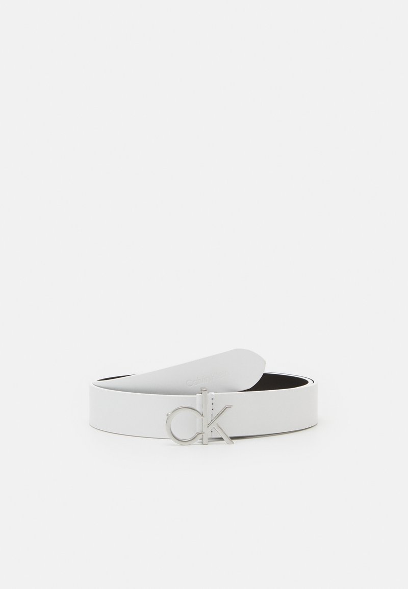 Ceinture en cuir blanc avec boucle logo "ck" argentée, présentée enroulée sur un fond blanc uni.