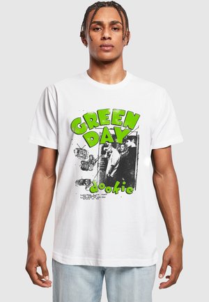 White cotton T-shirt featuring a bold green "GREEN DAY" logo and black and white graphic. Casual fit with round neckline and short sleeves.