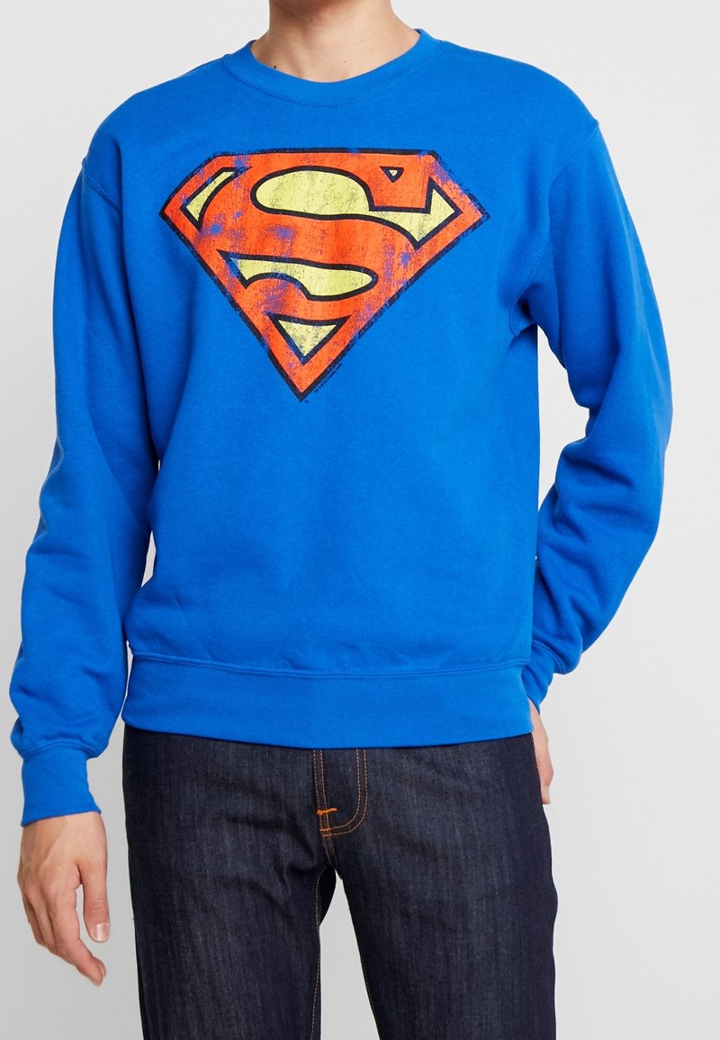 Felpa blu con un grande logo di Superman, logorato, in rosso e arancione sul davanti. Realizzata in cotone con polsini e orlo a coste.
