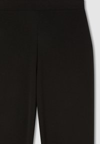 Pantaloni neri attillati con taglio dritto e senza chiusure visibili, mostrati dalla vita a metà coscia su uno sfondo semplice.