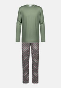 Olijfgroene top met lange mouwen, gecombineerd met gestreepte broek met ronde motieven in rood, blauw en wit tegen een zwarte achtergrond.