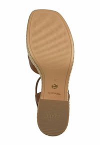 Sandale en cuir marron avec une semelle texturée, dotée d'un talon légèrement surélevé et d'accents tissés le long des bords. Taille 37 imprimée à l'intérieur.