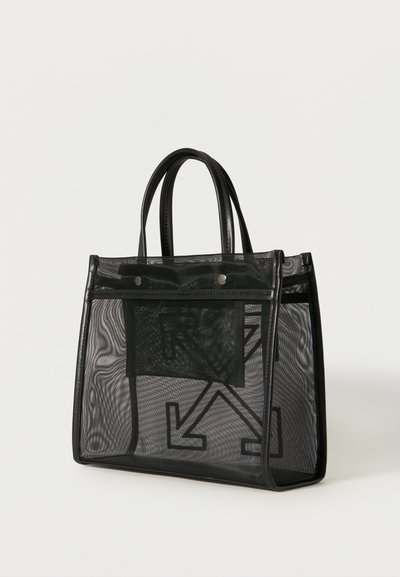 Μαύρη διαφανής τσάντα δίχτυ με δύο χειρολαβές και έντονο μαύρο βέλος στο μπροστινό μέρος, πάνω σε λευκό απλό φόντο.