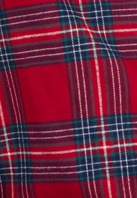 Tessuto a scacchi rosso con linee verdi e bianche, caratterizzato da una consistenza morbida e un motivo di strisce incrociate che creano un design a quadri.