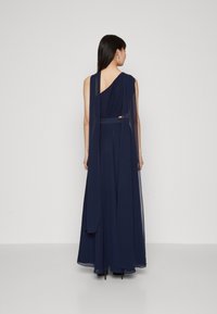 Robe en chiffon bleu marine avec un design à une épaule, tissu drapé et une longue traîne. Longueur au sol avec une silhouette fluide.