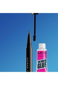 Crayon à sourcils noir à pointe fine et tube ouvert de NYX The Brow Glue avec brosse spoolie visible sur fond bleu.