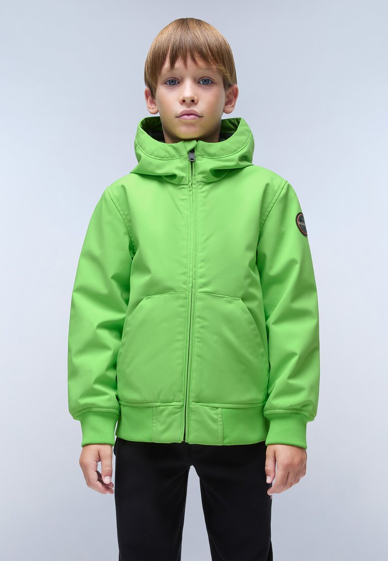 Giacca verde con zip e cappuccio, realizzata in tessuto morbido e leggero. Presenta tasche frontali e un logo circolare sulla parte superiore della manica.