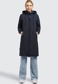 Cappotto imbottito blu navy con cappuccio, zip frontale, due tasche laterali e cordini regolabili. Maniche lunghe con polsini elasticizzati.