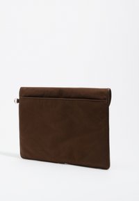 Brązowa etui na laptopa wykonana z miękkiego, teksturowanego materiału. Charakteryzuje się składaną konstrukcją z subtelnym szwem oraz małą metalową pętlą z boku.