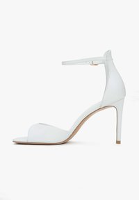 Witte sandalen met hoge hakken, voorzien van een open teenontwerp, verstelbare enkelband en een gladde leren afwerking met een slanke stilettohol.