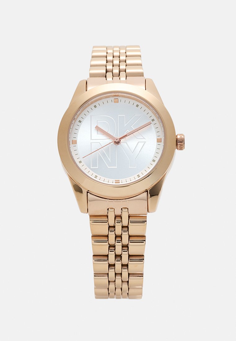 Roségoldfarbene Armbanduhr mit rundem Ziffernblatt, silbernem Ziffernblatt mit DKNY-Logo und einem Metall-Gliederarmband. Minimalistisches Design mit glatter Textur.