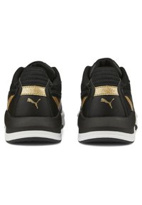 Czarne buty sportowe z teksturowaną cholewką i złotymi akcentami oraz białą podeszwą. Wzór zawiera widoczne logo na pięcie.