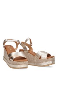 Sandalias de cuña metálica dorada con tiras cruzadas, tejido texturizado y plantilla acolchada. Correa de tobillo ajustable para un ajuste seguro.