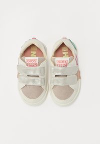 Hvite sneakers med metalliske sølvstropper, semsket beige akenter og fargerike stjerneapplikasjoner. Har en polstret såle og gummiyttersåle.