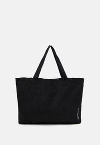 Svart tote-väska i kraftig tyg, med två långa handtag och en enkel rektangulär form. Inga mönster eller ytterligare detaljer synliga.
