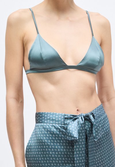 Bralette triangolare in raso turchese chiaro con spalline sottili, abbinato a pantaloni avvolgenti coordinati con fantasia e fiocco in vita.