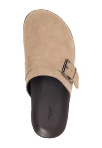 Beige suede slip-on sandal with a wide strap and a metallic buckle detail. Black footbed. Smooth texture and minimalist design.