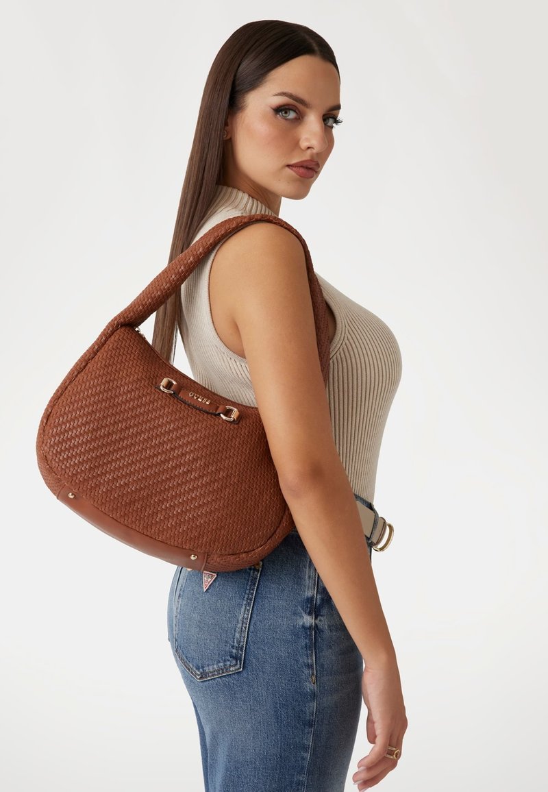 Borsa intrecciata marrone a forma curvata, con rifiniture in pelle e accessori in metallo. La texture appare lavorata, con un delicato motivo.
