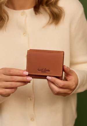 Brun læderpung med en glat tekstur, der har prægede varemærker. Kompakt rektangulær form med kontrastsygning.