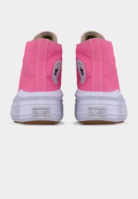 Ροζ ψηλά αθλητικά παπούτσια Converse All Star, εμφανιζόμενα από πίσω, με λευκές σόλες και λογότυπα στις πλευρές.