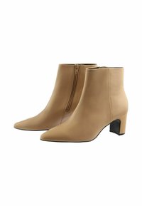 Beige kožené kotníkové boty s špičatou špičkou a středně vysokým blokovým podpatkem. Obsahují vertikální zip na boku pro zapínání.