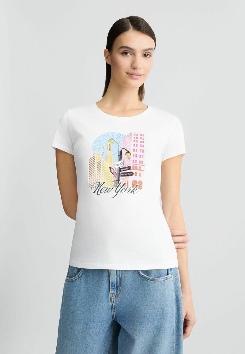 Un t-shirt en coton blanc avec un impression graphique colorée du paysage urbain de New York. Encolure ronde, manches courtes, coupe décontractée et éléments de design ludiques.